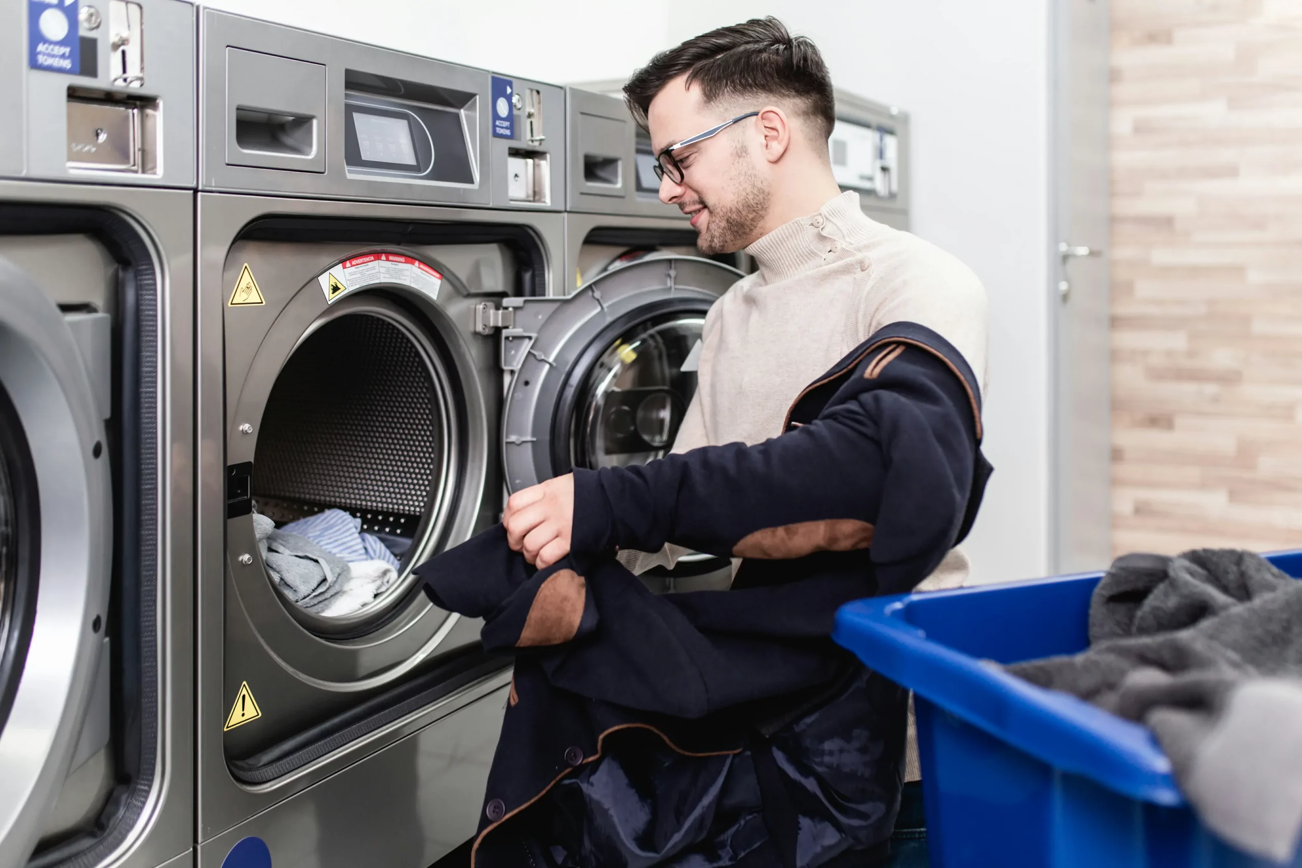 handsome-young-businessman-doing-his-weekly-washing-laundromat